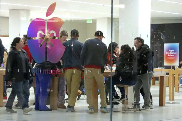 FILE - Shoppers look at Apple products in the Apple Store at the Walden Galleria in Buffalo, NY, on Saturday, Nov. 30, 2024. (AP Photo/Gene J. Puskar, File)