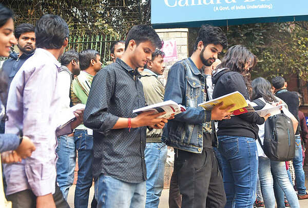 Students study while standing in a queue outside an ATM at the back gate of Hans Raj College (BCCL)
