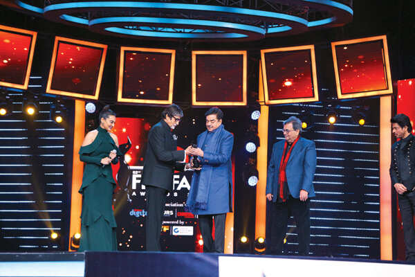 Amitabh Bachchan presenting lifestime achievement award to Shatrughan Sinha while Sonakshi looks on