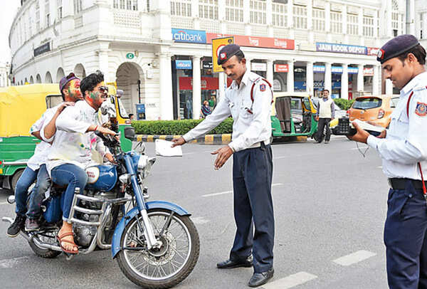 (L-R) Bhavesh Kumar and Niteesh Taragi from Deshbandhu College’s dramatics society (street theatre), and Manish Jatolia play out a scene the cops see each Holi – high-on-bhaang riders flouting traffic rules (BCCL)