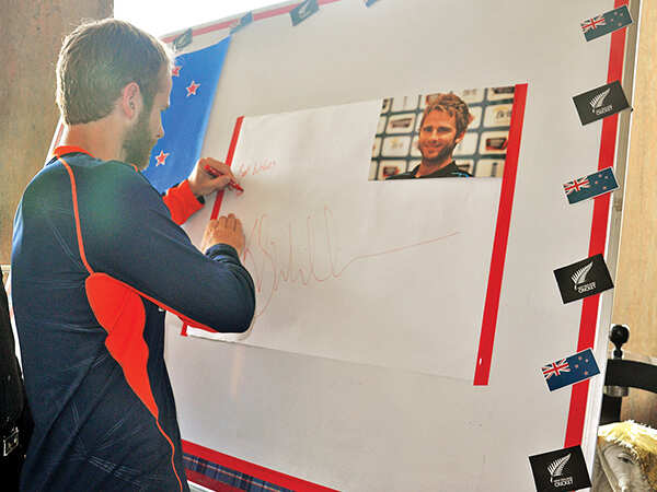 Kane signing a message board set up at the school in Kanpur (BCCL/ AS Rathor)