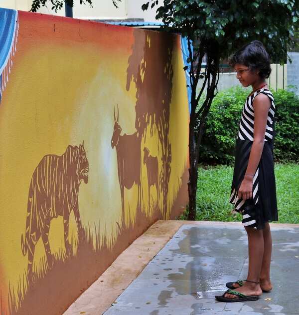 5c- a child watches tiger and cow story depicted on a wall - Copy