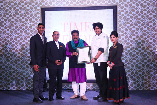 Best Continental (Premium) Jal Mahal Abhimanyu Agarwal, Sujit Das, Chef Navneet Singh and Lakshika Singh receive the award from sculptor Arjun Prajapati