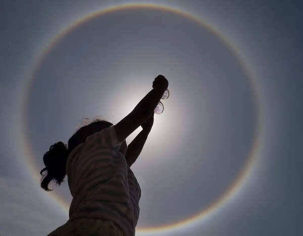 Bengaluru: A woman looks on at a sun halo in Bengaluru. (PTI Photo)(...