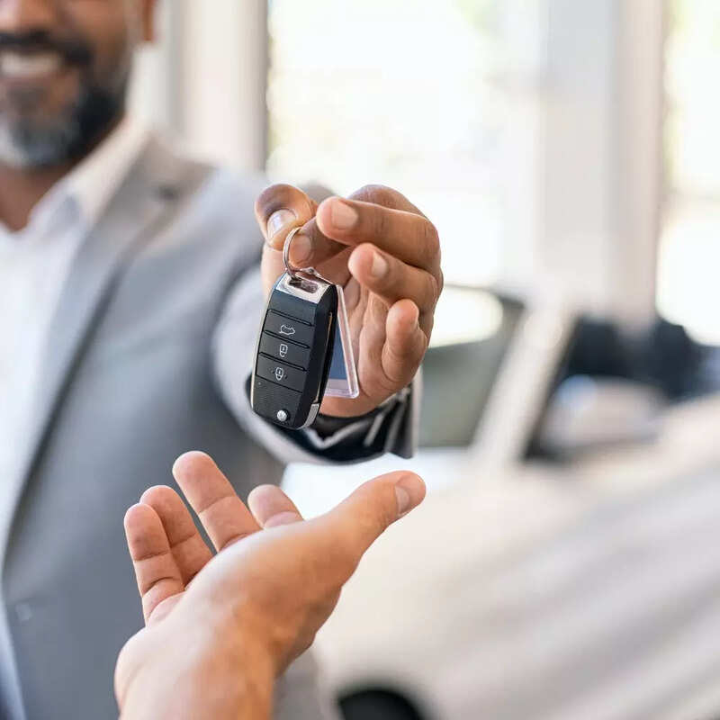 salesman-giving-new-car-keys-to-customer-picture-id1138560072