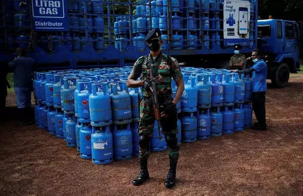 An armed soldier stands guard next to domestic cooking gas cylinders before their distribution, amid the country's economic crisis, in Colombo.