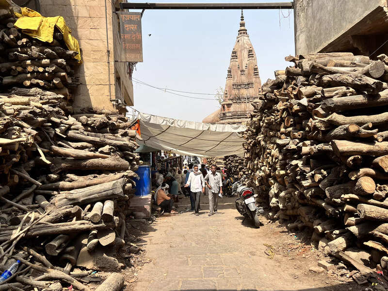 The humongous piles of wood are the first sign that the burning ghats are close