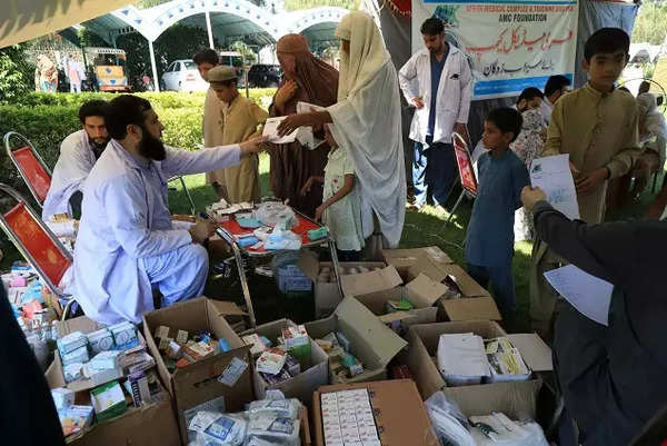 Women and children receive medical assistance at a relief camp for flood victims following rains and floods during the monsoon season in Charsadda.