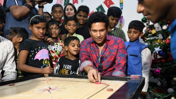Tendulkar plying carrom with children at Happy Feet Home