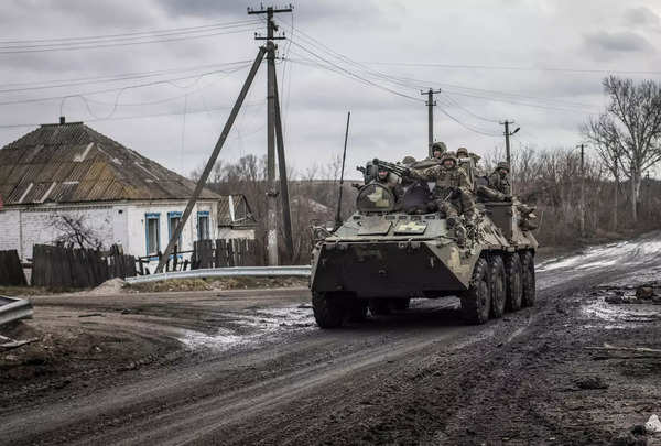 यूक्रेन के सैनिक तोर्स्के गांव में एक बख़्तरबंद कार्मिक वाहक की सवारी करते हुए
