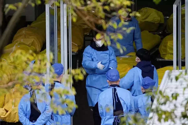 Staff members speak next to several body bags at a funeral home, as coronavirus disease (COVID-19) outbreaks continue in Shanghai.