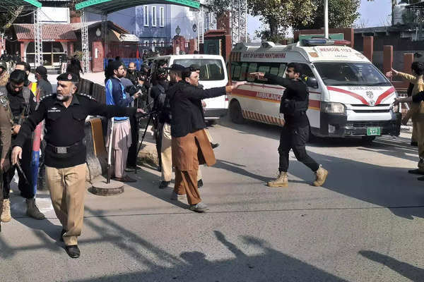 Police officers clear the way for ambulances leaving after carrying wounding peo....