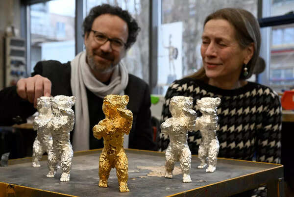 Berlinale Executive Director Mariette Rissenbeek (R) and Berlinale Artistic Director Carlo Chatrian look at Berlinale Bear trophies.
