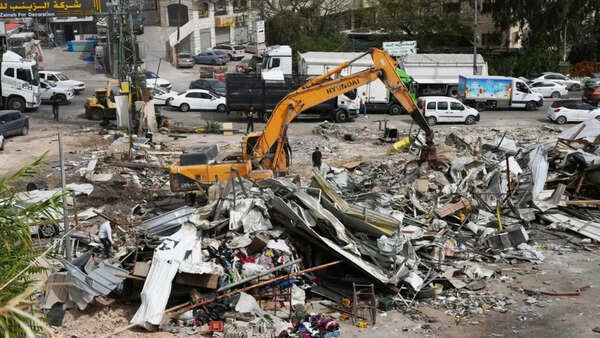 Israeli bulldozers raze about 50 Palestinian shops ahead of settlement-linked road project