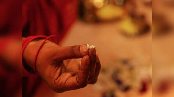 Which is the right finger to apply tilak?
