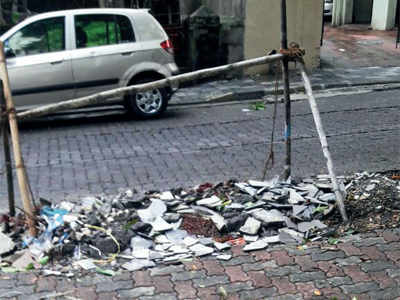 Mumbai residents use rubble abandoned in sacks outside homes to fill potholes