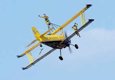 How do these girls smile while standing atop an aircraft cruising ...