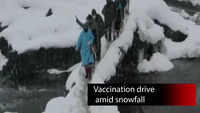 J&K: Officials of Health Department carry out vaccination drive amid snowfall 