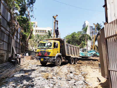 Trucks bearing MMRCL signage dump construction debris in Wadala