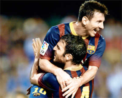 Messi hat-trick keeps Barca on top