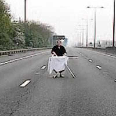 Man irons shirt on closed highway