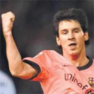 Messi hat-trick sends Barca top