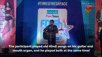 Participant plays guitar and mouth organ at the same time at mall audition 