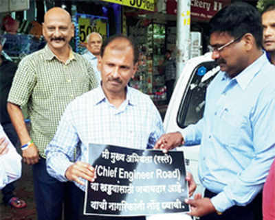 Engineer hoisted on potholes, forced to hold this placard