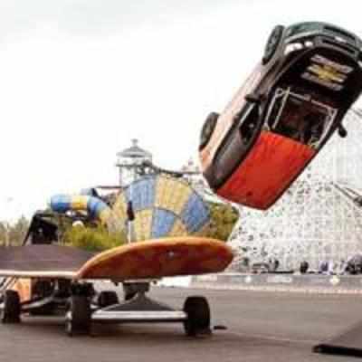 Daredevil skateboarder does a 360 degree flip... with a car