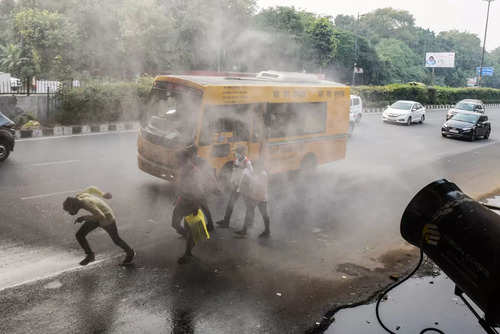 A smog gun sprinkles water on the road to 'curb' pollution amid heavy smog near ISBT Ring Road in Delhi on Monday.