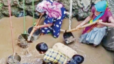Kids dig well with bare hands to quench thirst