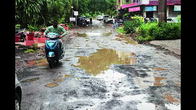Bone-jarring clash of two worlds: Potholed roads in plush localities
