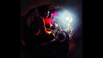 Under a highway, workers chip away at basalt rock to lay Baner-Balewadi water conduit