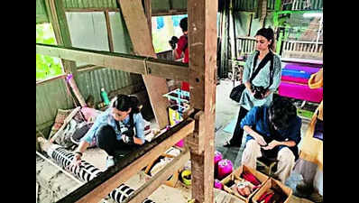 Students learn from skilled weavers