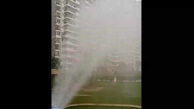 Noida: Condo residents sprinkle water to fight dust from nearby plot