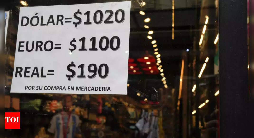 Argentina devalues its currency and cuts subsidies as part of shock economic measures – Times of India