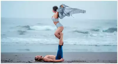 Pregnant Woman with Husband Expecting Baby with Yoga Pose at Beach