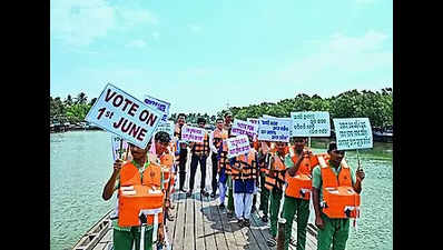Poll officials take a boat ride to Batighar to urge islanders to vote