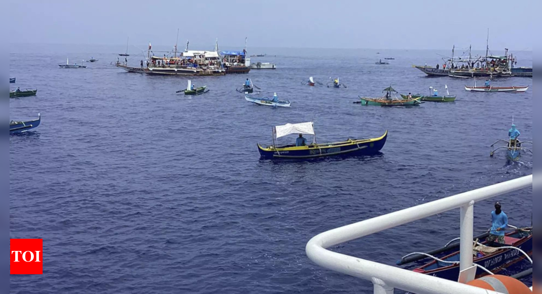 About 100 Filipino activists and fishermen sail on wooden boats to disputed shoal guarded by China – Times of India