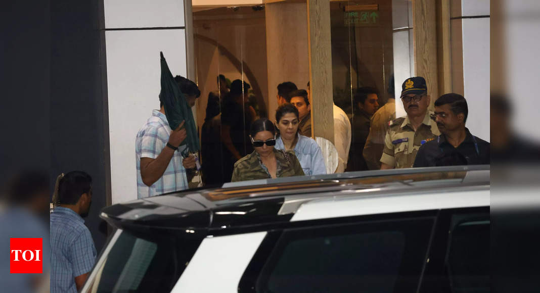 SRK returns to Mumbai, shields his face under umbrella