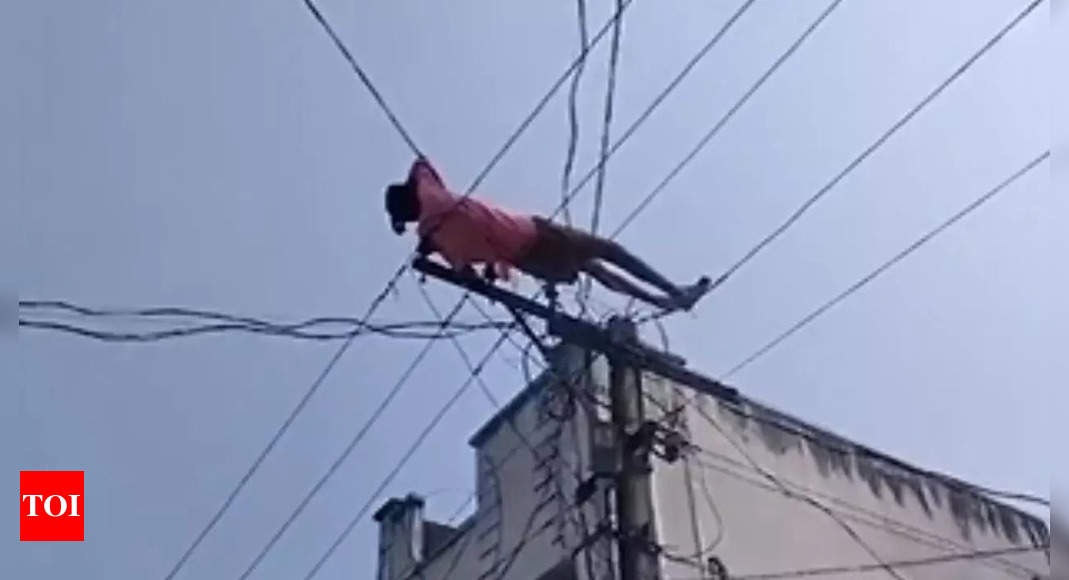 Watch: Drunk man climbs electric pole, lies on electric wires over denied money