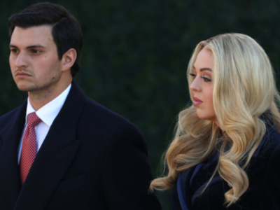 Tiffany Trump wraps herself in a navy blue floor-length coat dress for Trump's inauguration