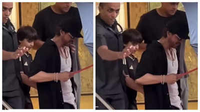 Shah Rukh Khan holds umbrella for son AbRam Khan on their latest outing as they twin in matching black outfits - WATCH video