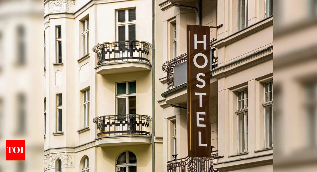 Why do travelers prefer living in hostels and camps rather than booking a hotel room?