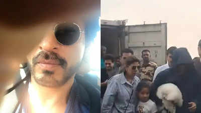 Shah Rukh Khan struggles to hide his face from paparazzi as he returns to Mumbai with Gauri Khan and their son AbRam