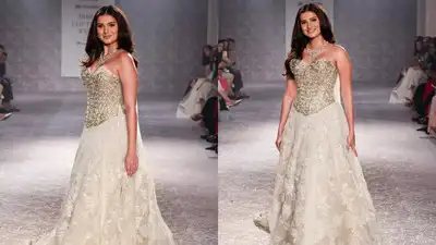 Tara Sutaria captivated at India Couture Week, walking for Rose Room by Isha Jajodia in a stunning ivory-gold gown. The vintage-inspired ensemble featured a structured corset and flowing lace skirt, complemented by soft makeup and romantic curls. A sweet moment occurred when she blew a kiss to Veer Pahariya, adding an unscripted touch to the fairytale-like show. Tara Sutaria brings vintage romance to the ramp