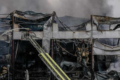 A firefighter works to extinguish a fire at a warehouse following a Russian attack, Saturday, Oct. 25, 2025, in Kyiv, Ukraine. (AP Photo/Julia Demaree Nikhinson) Russian attacks kill 4 in Ukraine as Zelenskyy pleads for air defence