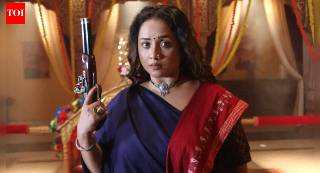 Rani Chatterjee portraying the fierce character Jwala, holding a gun with an intense expression.