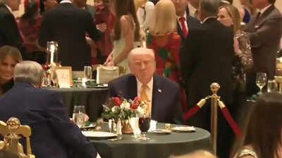 'Why are they sitting so far apart?': Trump goes third wheel with Melania and her father Viktor Knavs at Mar-a-Lago Christmas dinner — Watch