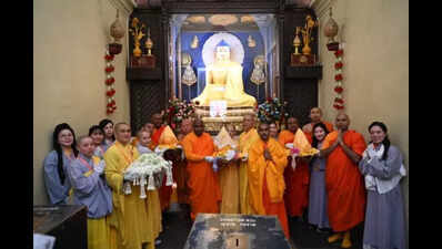 पर्यटक और भिक्षु बुद्ध अवशेषों के जुलूस में भाग लेते हैं